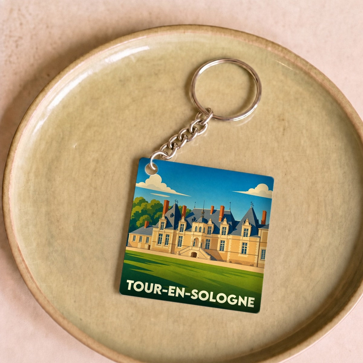 Porte-clés souvenir de la ville de Tour-en-Sologne avec une illustration stylisée du château de Villesavin.