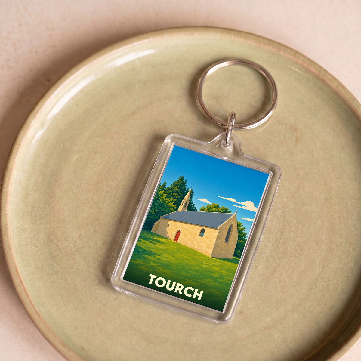 Porte-clés souvenir de la ville de Tourch avec une illustration stylisée d'une chapelle.
