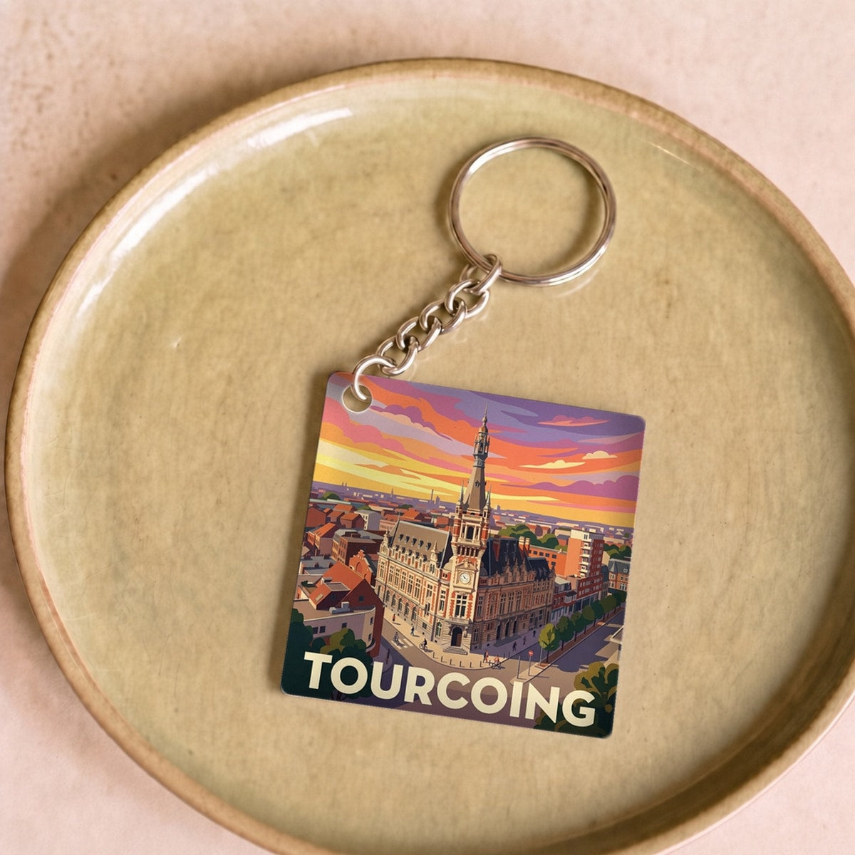 Porte-clés souvenir de la ville de Tourcoing avec une illustration stylisée du paysage urbain.
