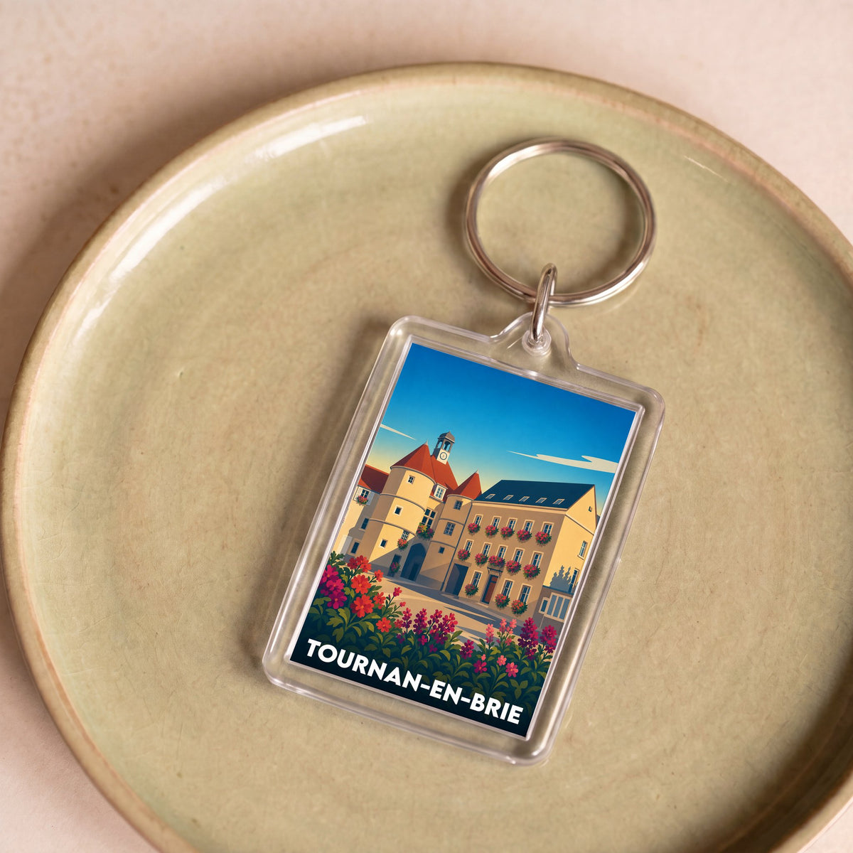 Porte-clés souvenir de la ville de Tournan-en-Brie avec une illustration stylisée.