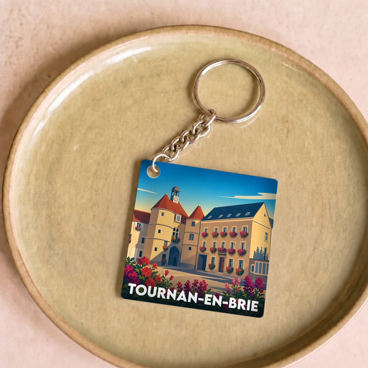 Porte-clés souvenir de la ville de Tournan-en-Brie avec une illustration stylisée.