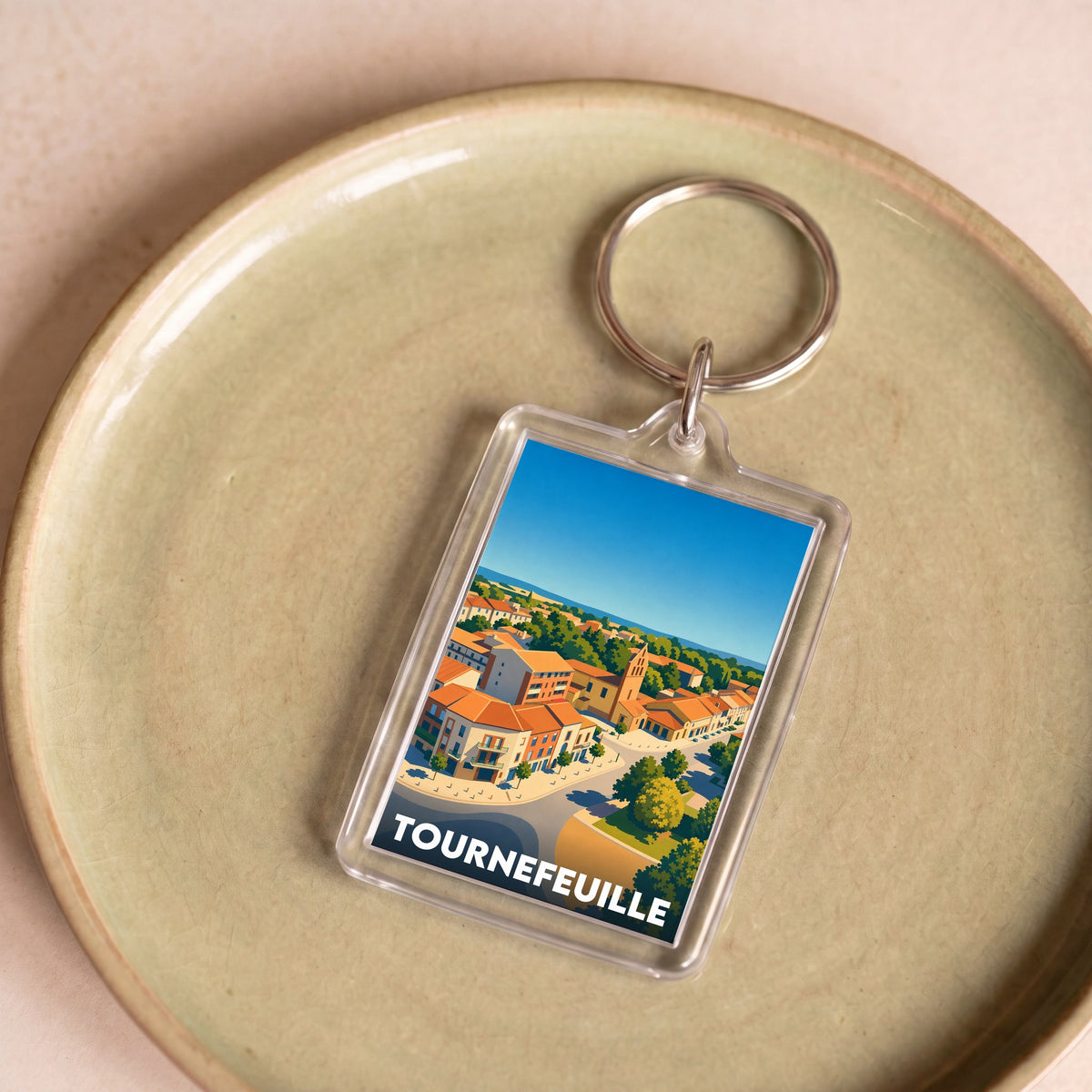Porte-clés souvenir de la ville de Tournefeuille avec une illustration stylisée.
