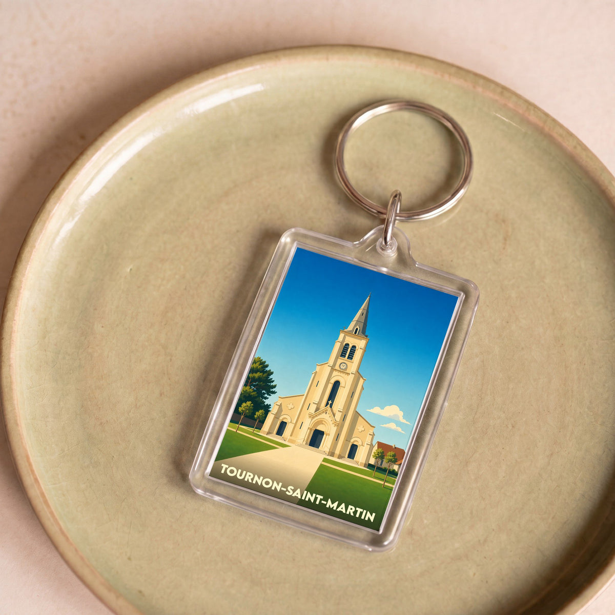 Porte-clés souvenir de la ville de Tournon-Saint-Martin avec une illustration stylisée de son église.