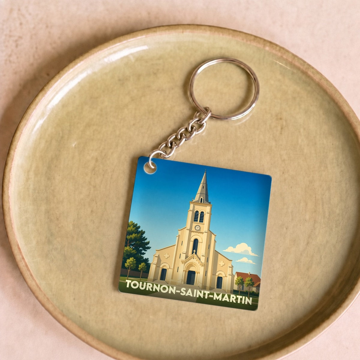 Porte-clés souvenir de la ville de Tournon-Saint-Martin avec une illustration stylisée de son église.