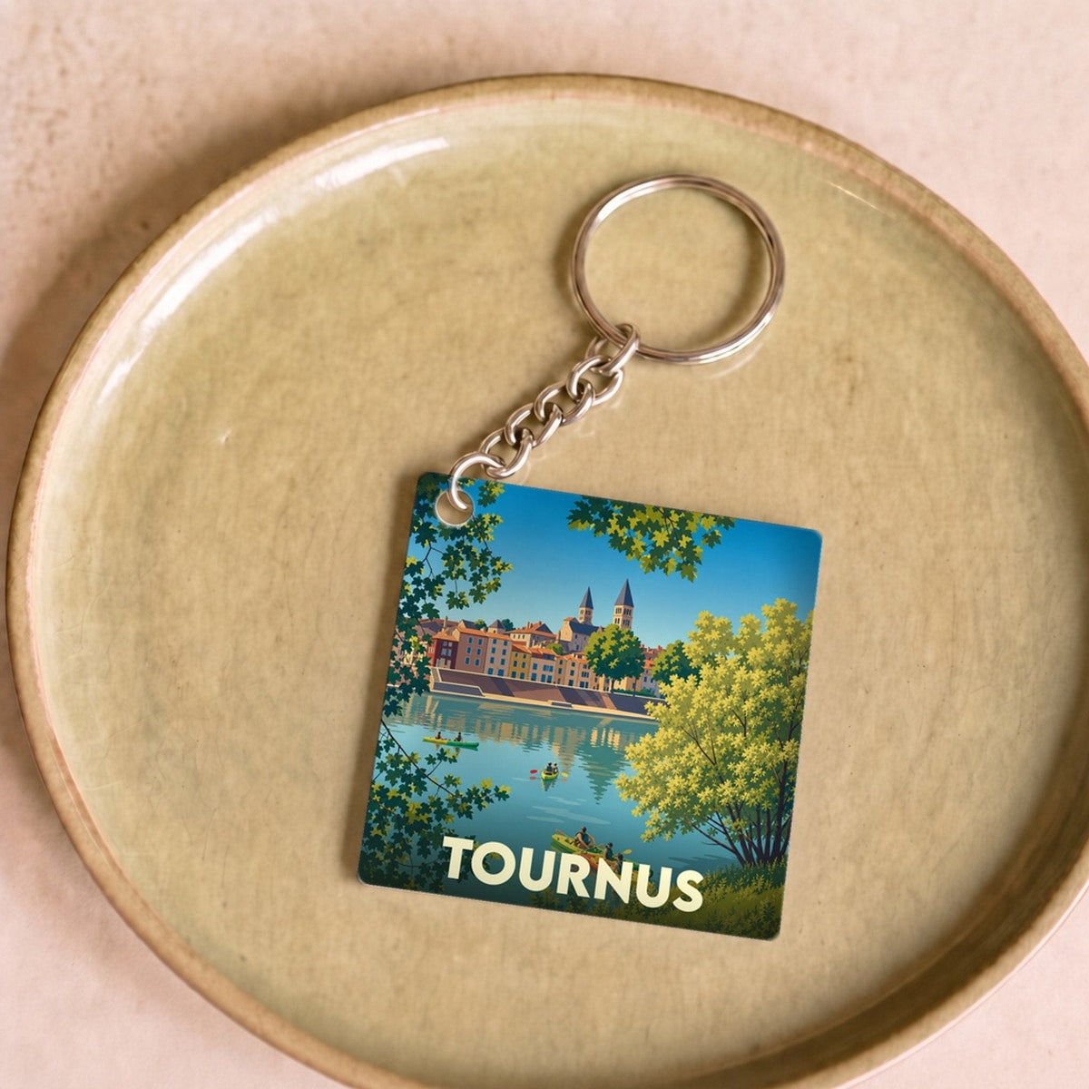 Porte-clés souvenir de la ville de Tournus avec une illustration stylisée d'une scène de canoë sur la Saône.