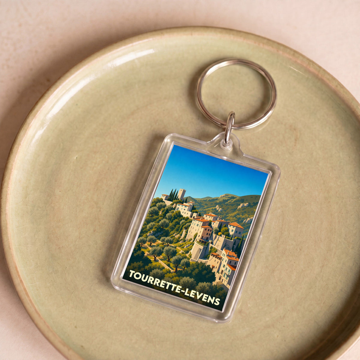Porte-clés souvenir de la ville de Tourrette-Levens avec une illustration stylisée.