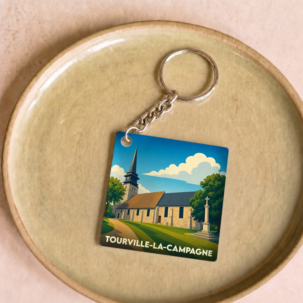 Porte-clés souvenir de la ville de Tourville-la-Campagne avec une illustration stylisée de son église.