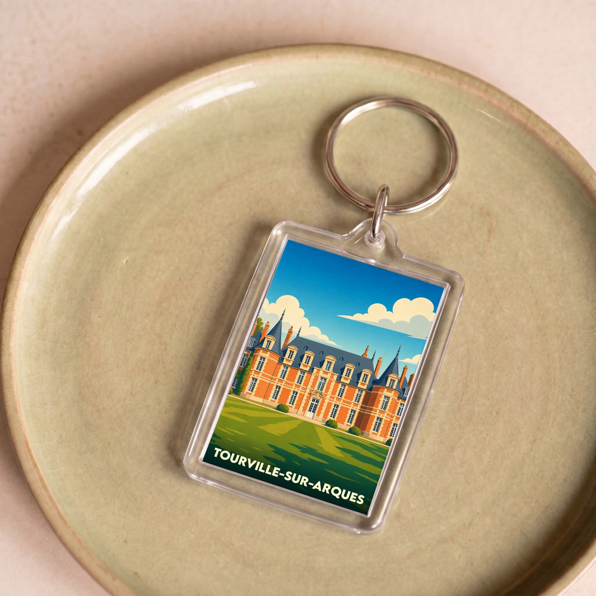 Porte-clés souvenir de la ville de Tourville-sur-Arques avec une illustration stylisée d'un château.
