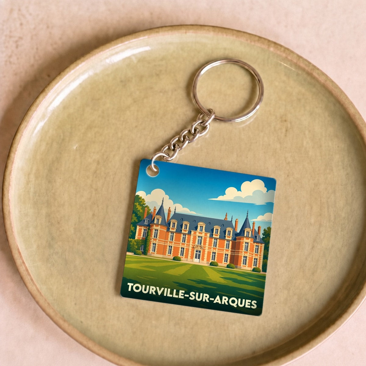 Porte-clés souvenir de la ville de Tourville-sur-Arques avec une illustration stylisée d'un château.