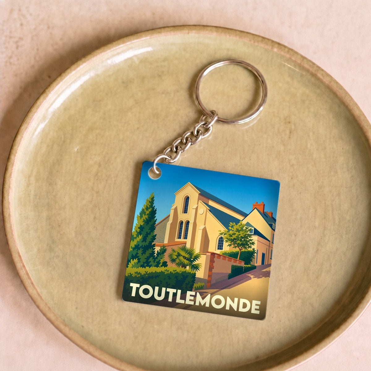 Porte-clés souvenir de la ville de Toutlemonde avec une illustration stylisée.
