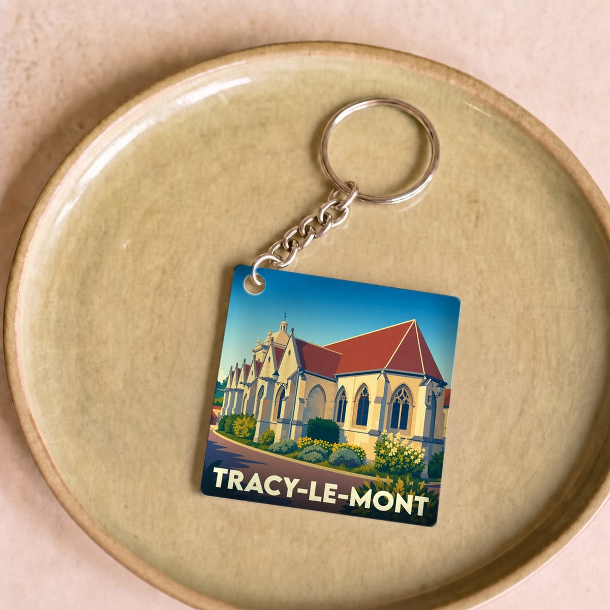 Porte-clés souvenir de la ville de Tracy-le-Mont avec une illustration stylisée de son église.