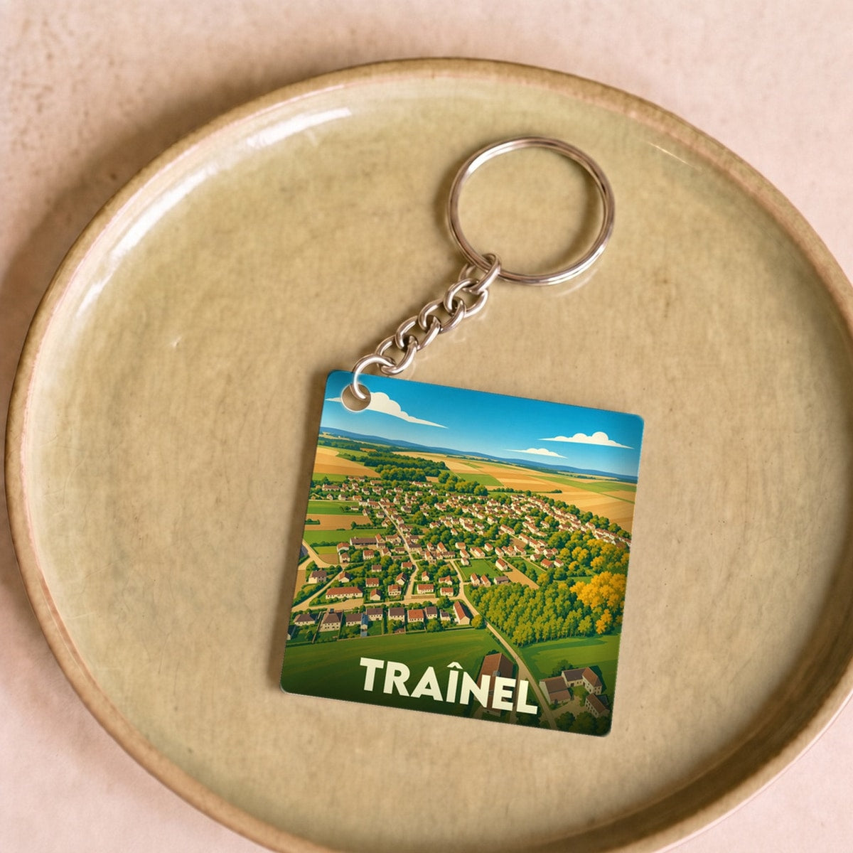 Porte-clés souvenir de la ville de Traînel avec une illustration stylisée vue du ciel.