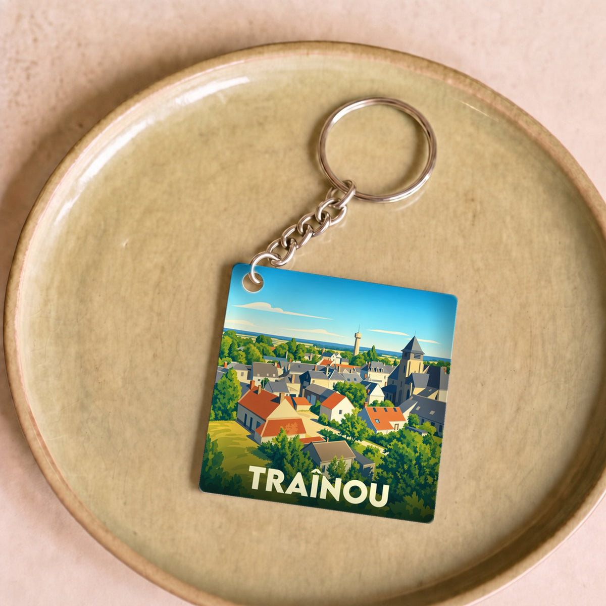 Porte-clés souvenir de la ville de Traînou avec une illustration stylisée.