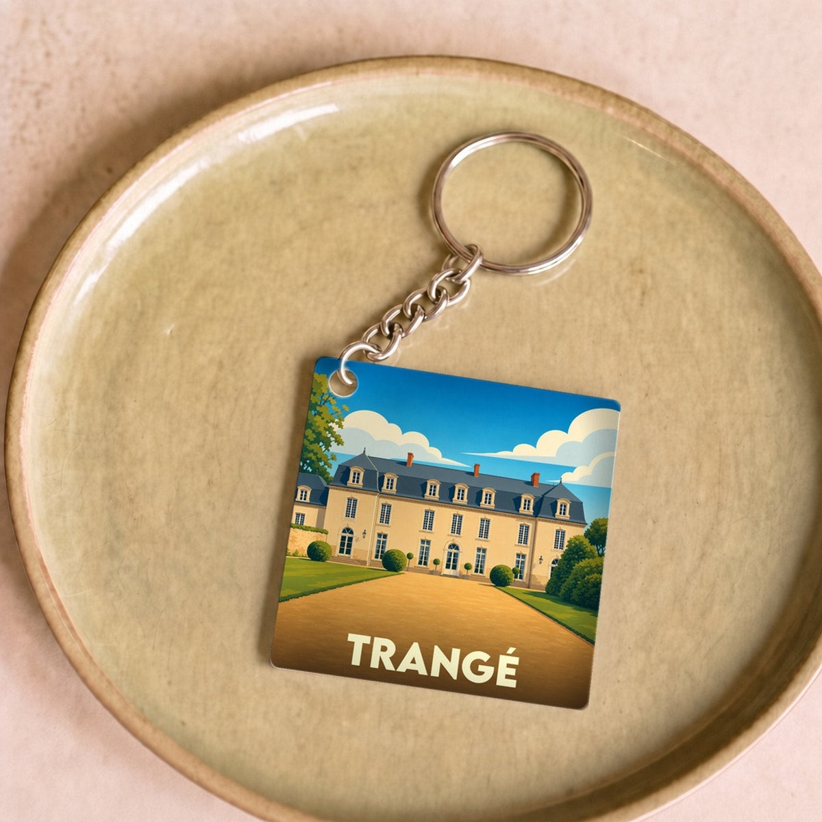 Porte-clés souvenir de la ville de Trangé avec une illustration stylisée d'un château.