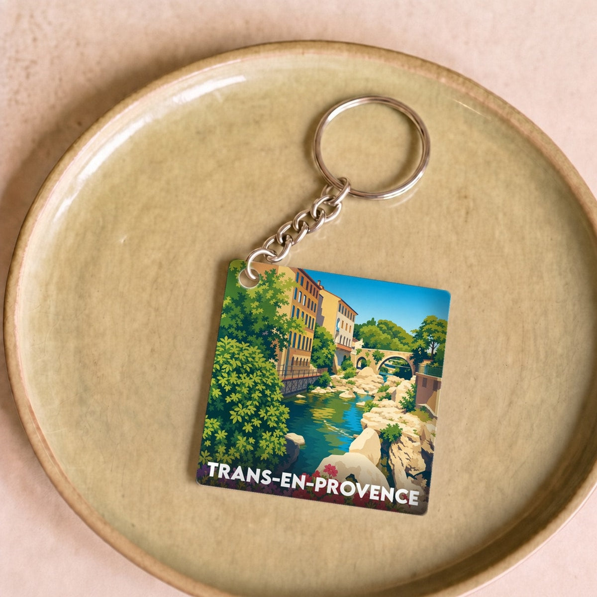 Porte-clés souvenir de la ville de Trans-en-Provence avec une illustration colorée et stylisée.