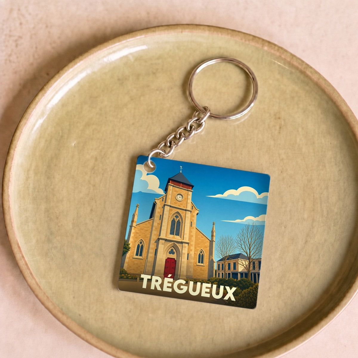 Porte-clés souvenir de la ville de Trégueux avec une illustration stylisée de son église.