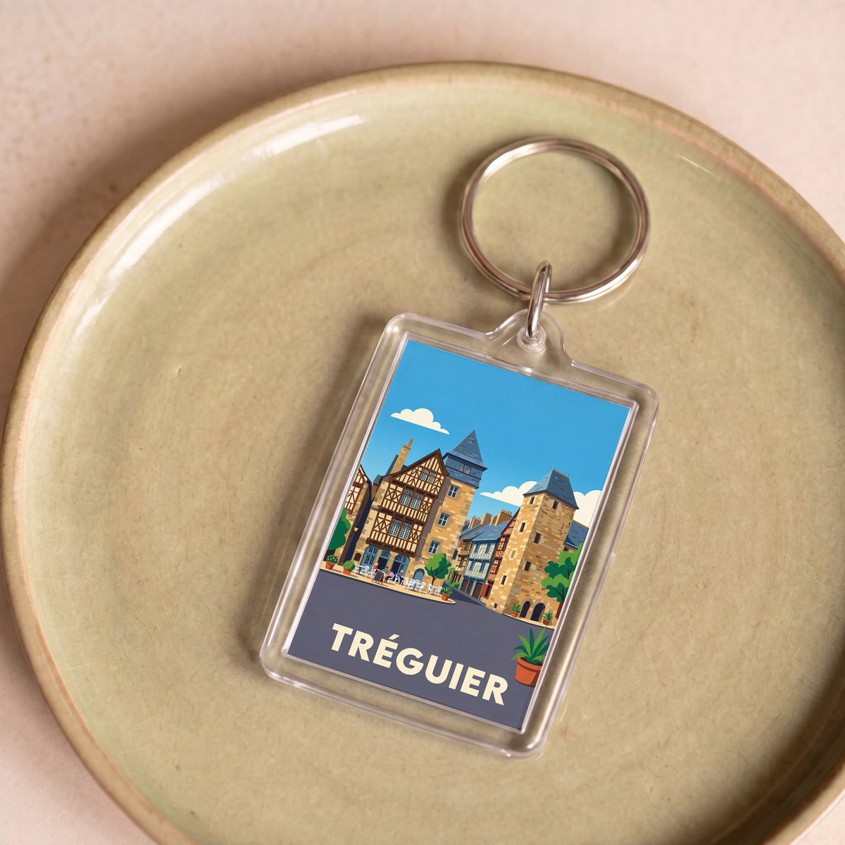 Porte-clés souvenir de la ville de Tréguier avec une illustration stylisée de son architecture historique.