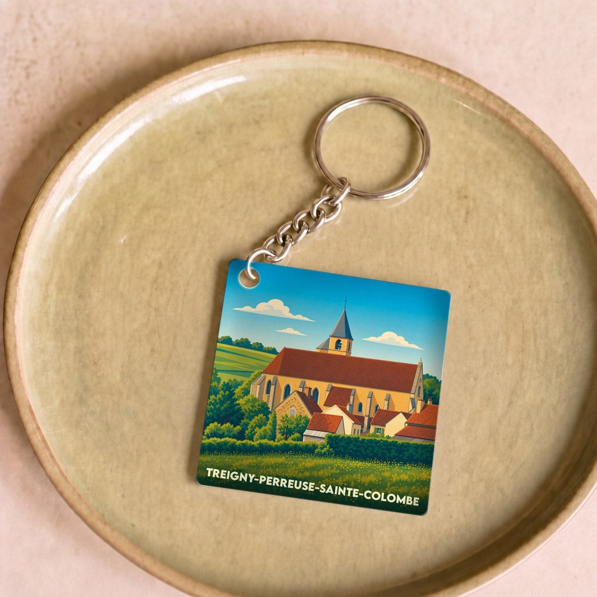 Porte-clés souvenir de la ville de Treigny-Perreuse-Sainte-Colombe avec une illustration stylisée.
