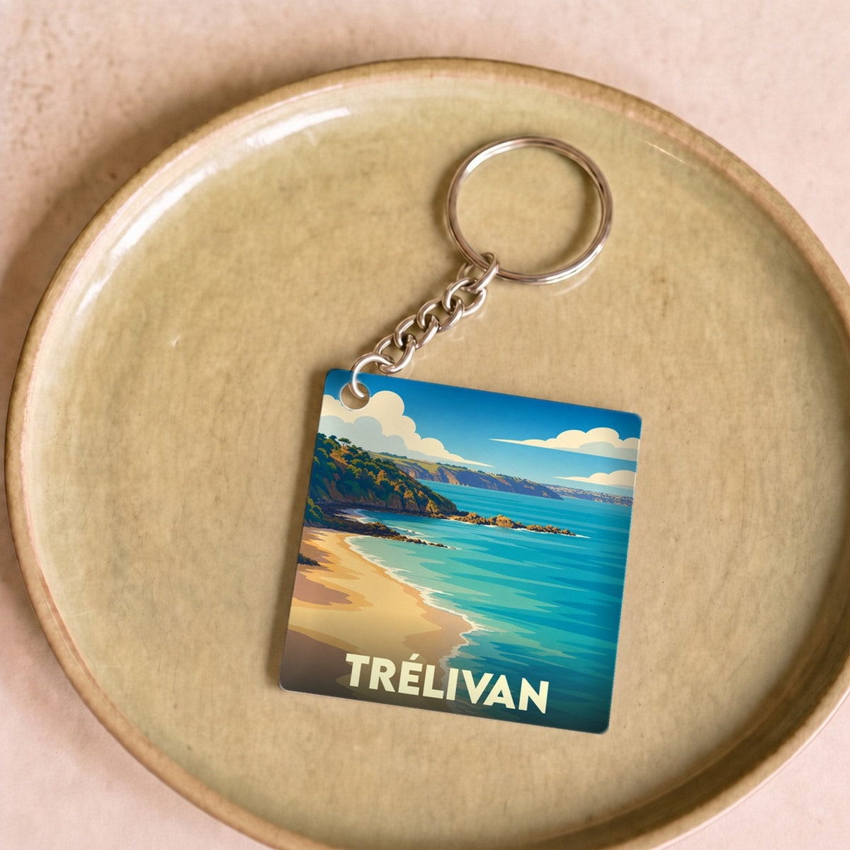 Porte-clés souvenir de la ville de Trélivan avec une illustration stylisée de bord de mer.