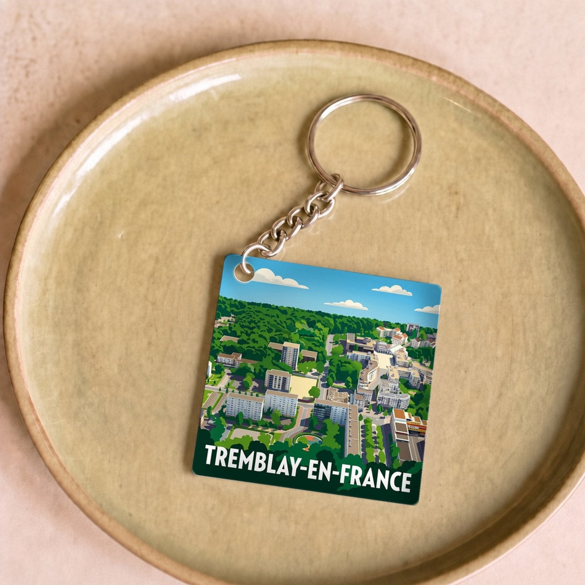 Porte-clés souvenir de la ville de Tremblay-en-France avec une illustration stylisée.