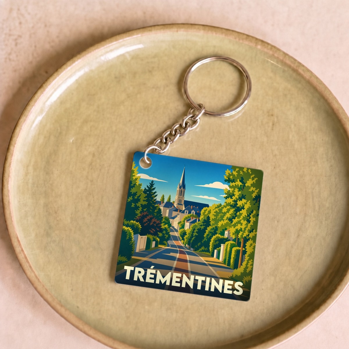 Porte-clés souvenir de la ville de Trémentines avec une illustration stylisée.