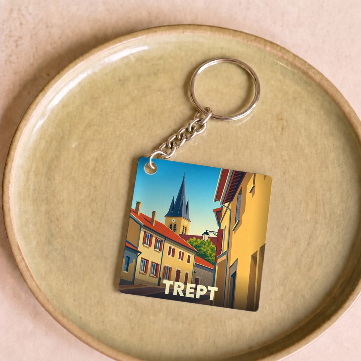 Porte-clés souvenir de la ville de Trept avec une illustration stylisée de ses bâtiments et de son clocher.
