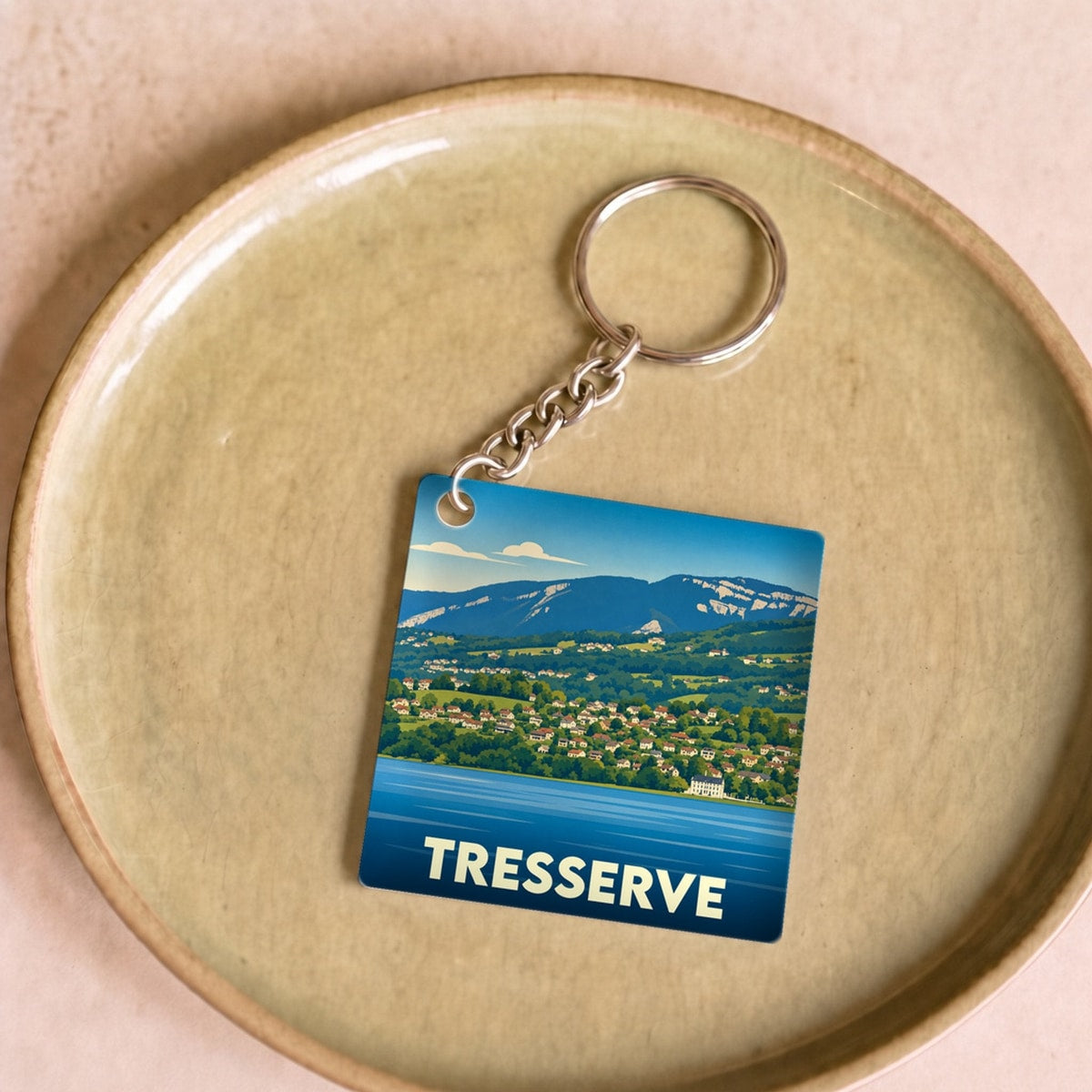 Porte-clés souvenir de la ville de Tresserve avec une illustration stylisée du lac et des montagnes.