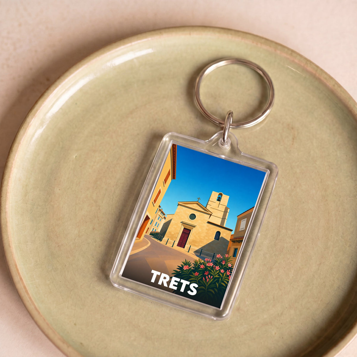 Porte-clés souvenir de la ville de Trets avec une illustration stylisée.