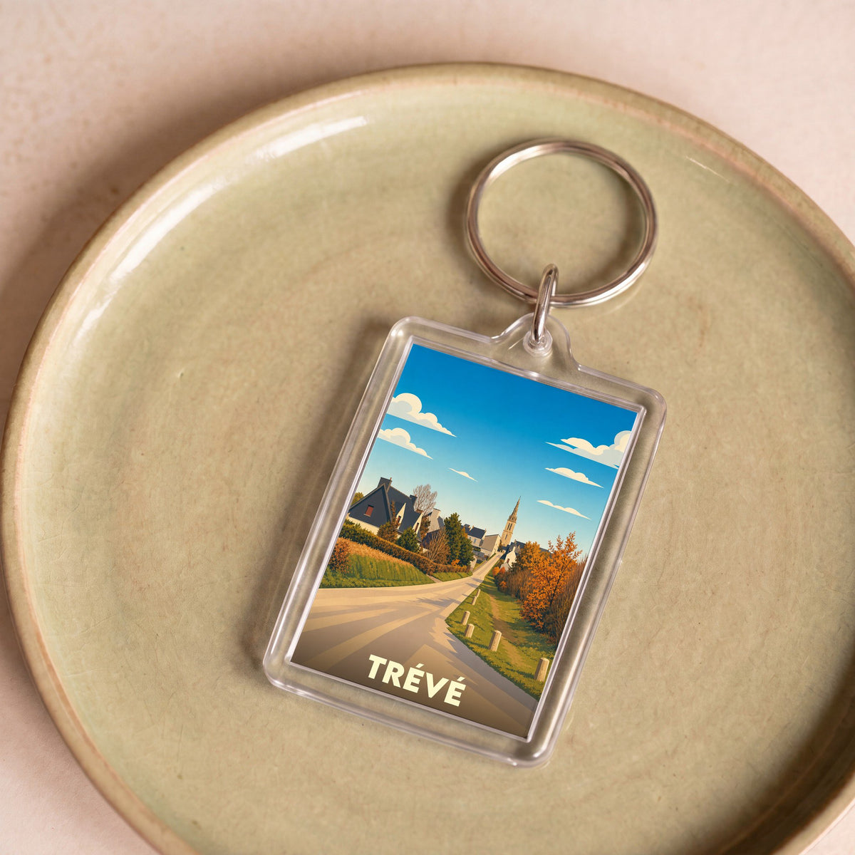 Porte-clés souvenir de la ville de Trévé avec une illustration stylisée.