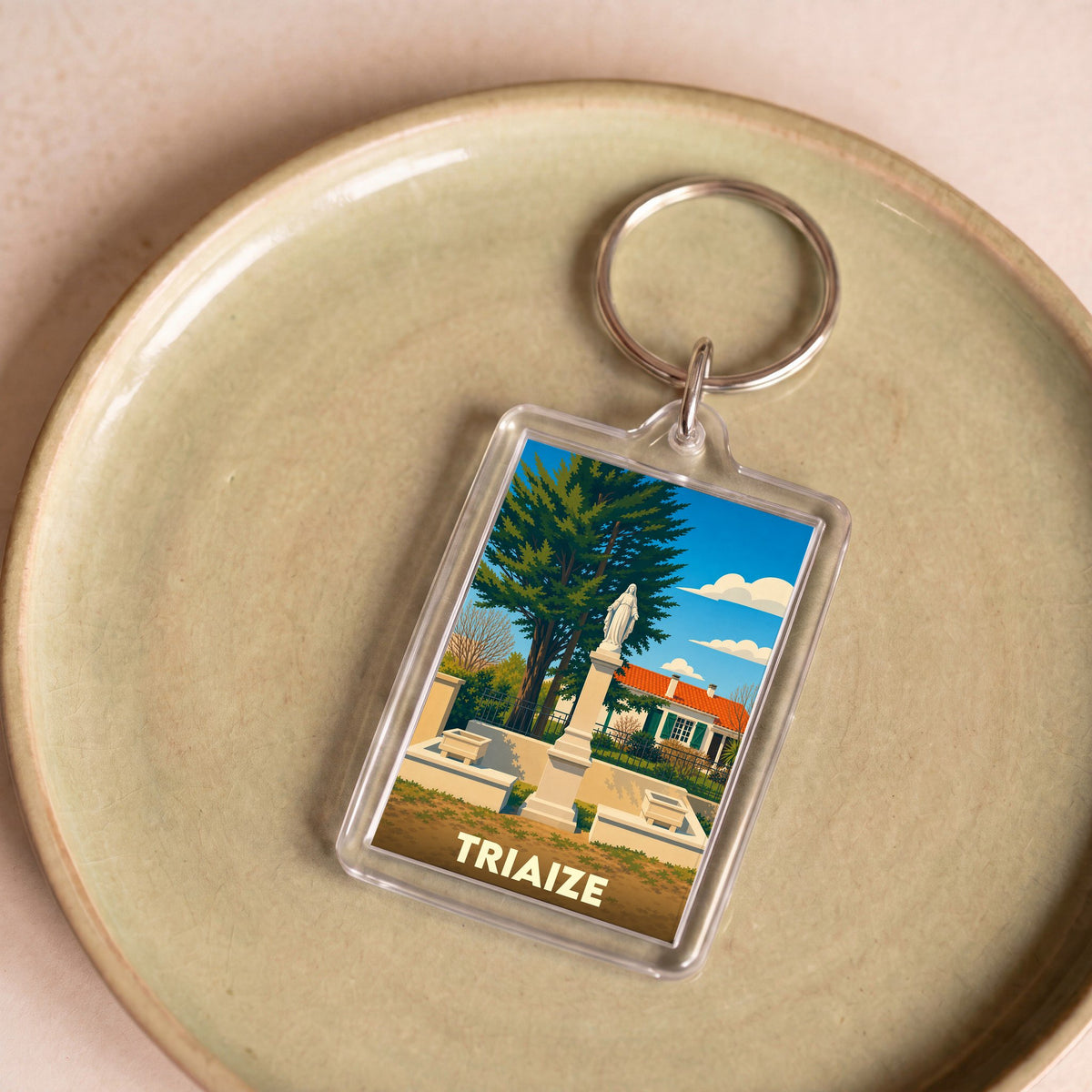 Porte-clés souvenir de la ville de Triaize avec une illustration stylisée d'un monument local.