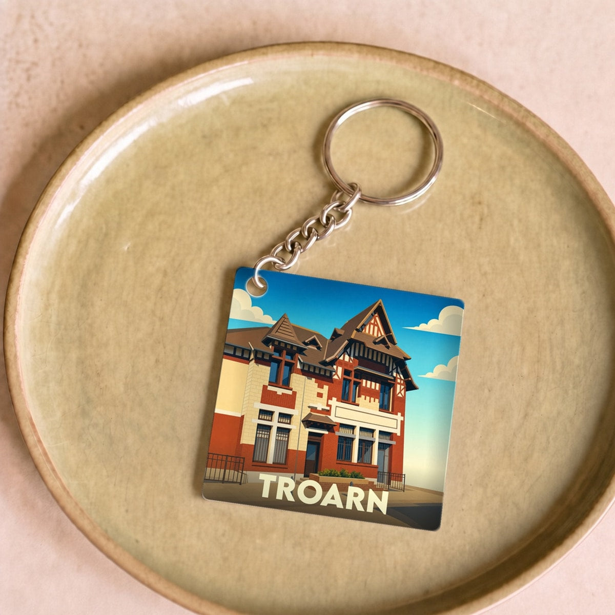 Porte-clés souvenir de la ville de Troarn avec une illustration stylisée de l'hôtel de ville.