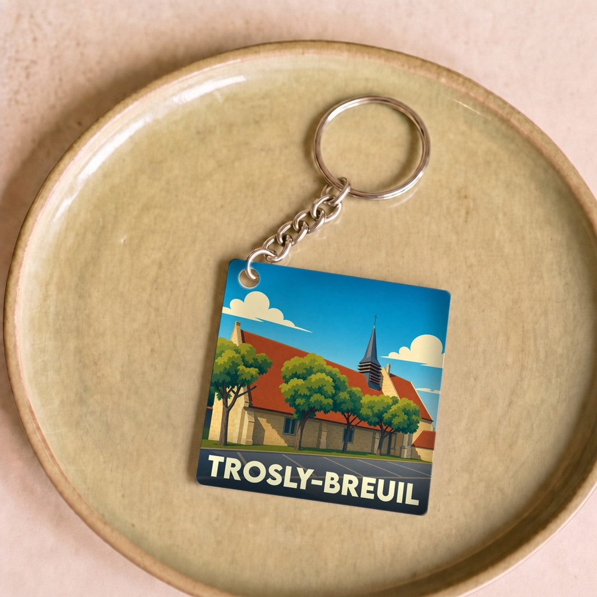 Porte-clés souvenir de la ville de Trosly-Breuil avec une illustration stylisée.