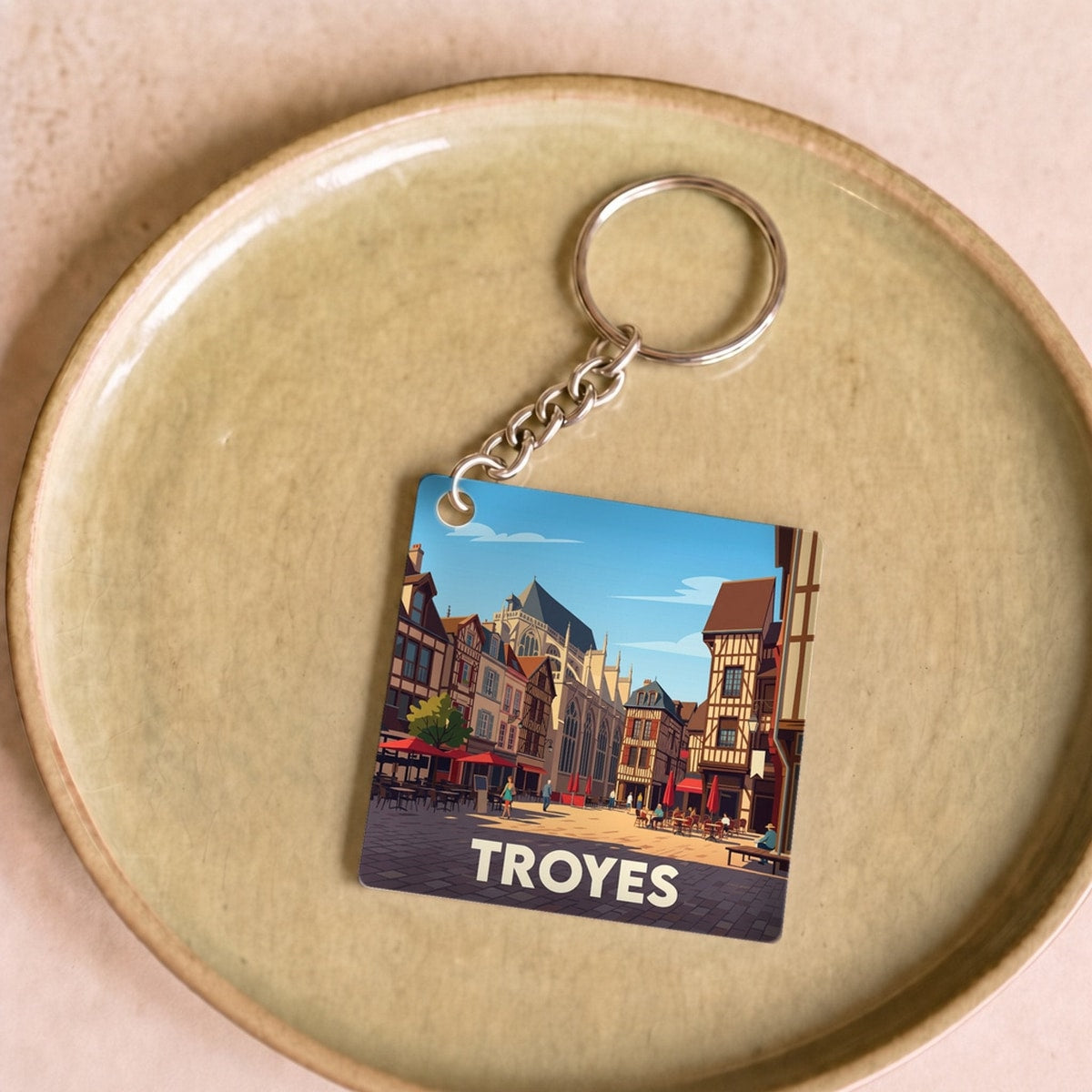 Porte-clés souvenir de la ville de Troyes avec une illustration stylisée de son architecture historique.