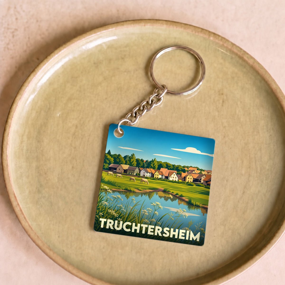 Porte-clés souvenir de la ville de Truchtersheim avec une illustration stylisée de son paysage champêtre.