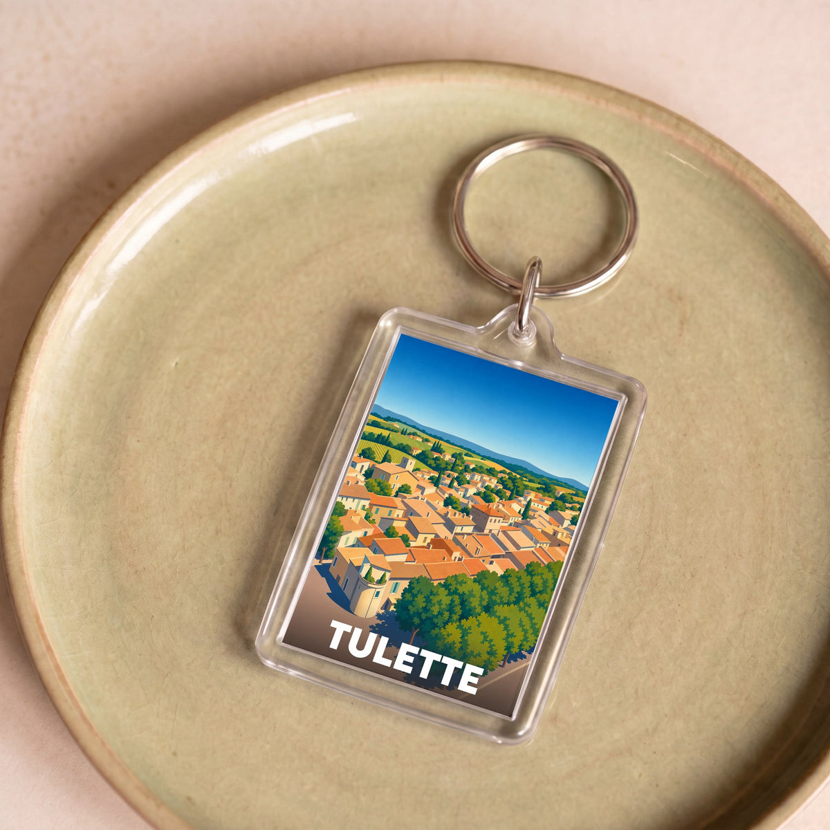 Porte-clés souvenir de la ville de Tulette avec une illustration stylisée.