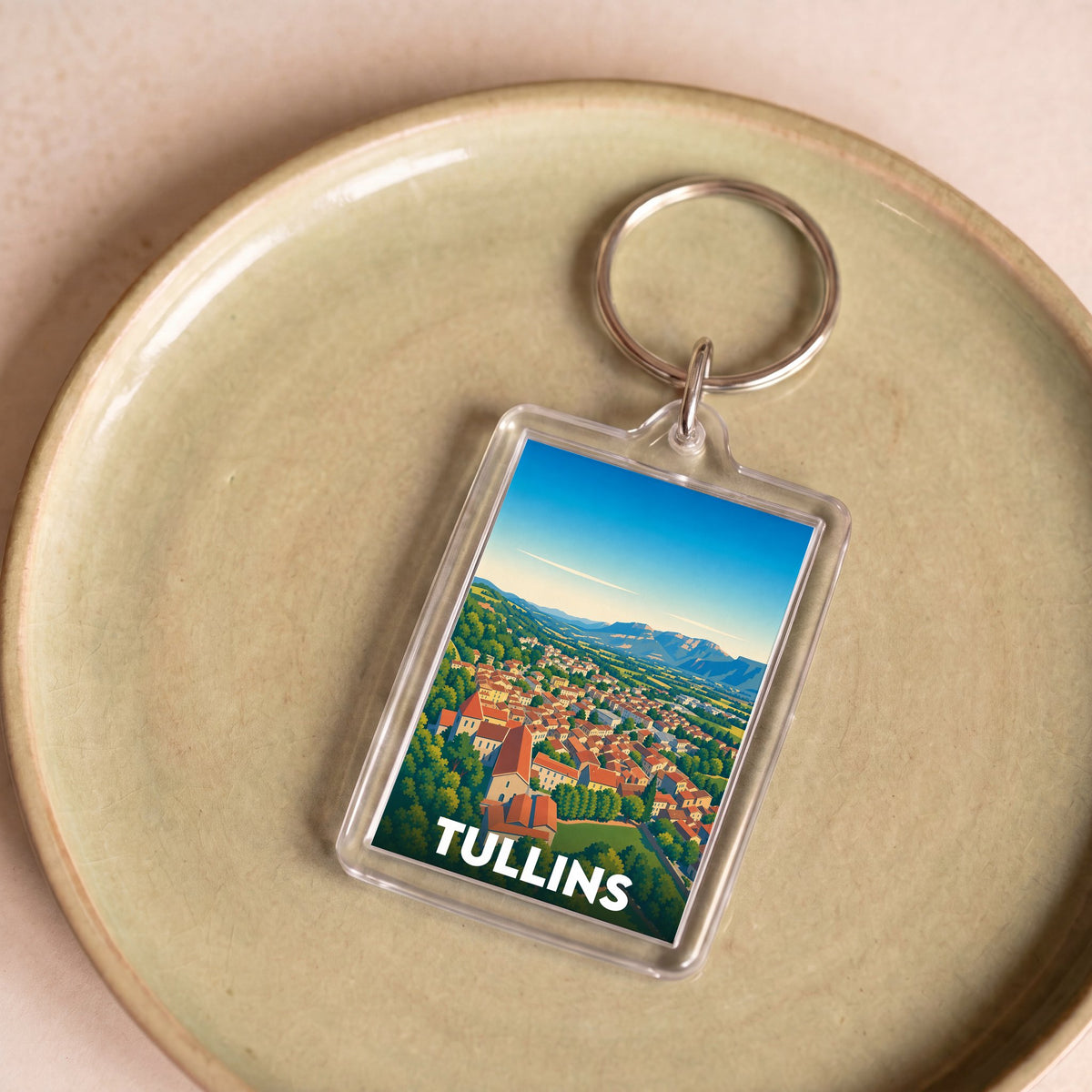 Porte-clés souvenir de la ville de Tullins avec une illustration stylisée de ses paysages.