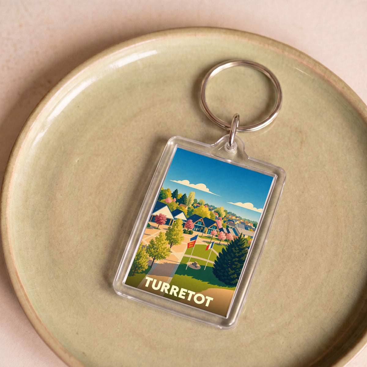 Porte-clés souvenir de la ville de Turretot avec une illustration stylisée.