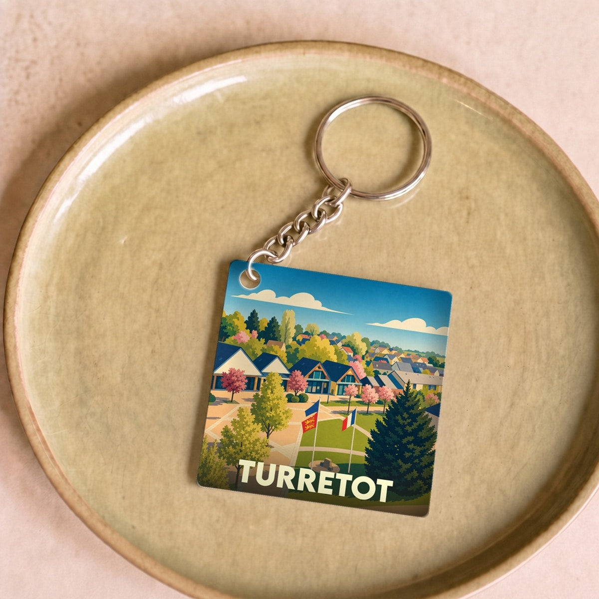 Porte-clés souvenir de la ville de Turretot avec une illustration colorée et stylisée.