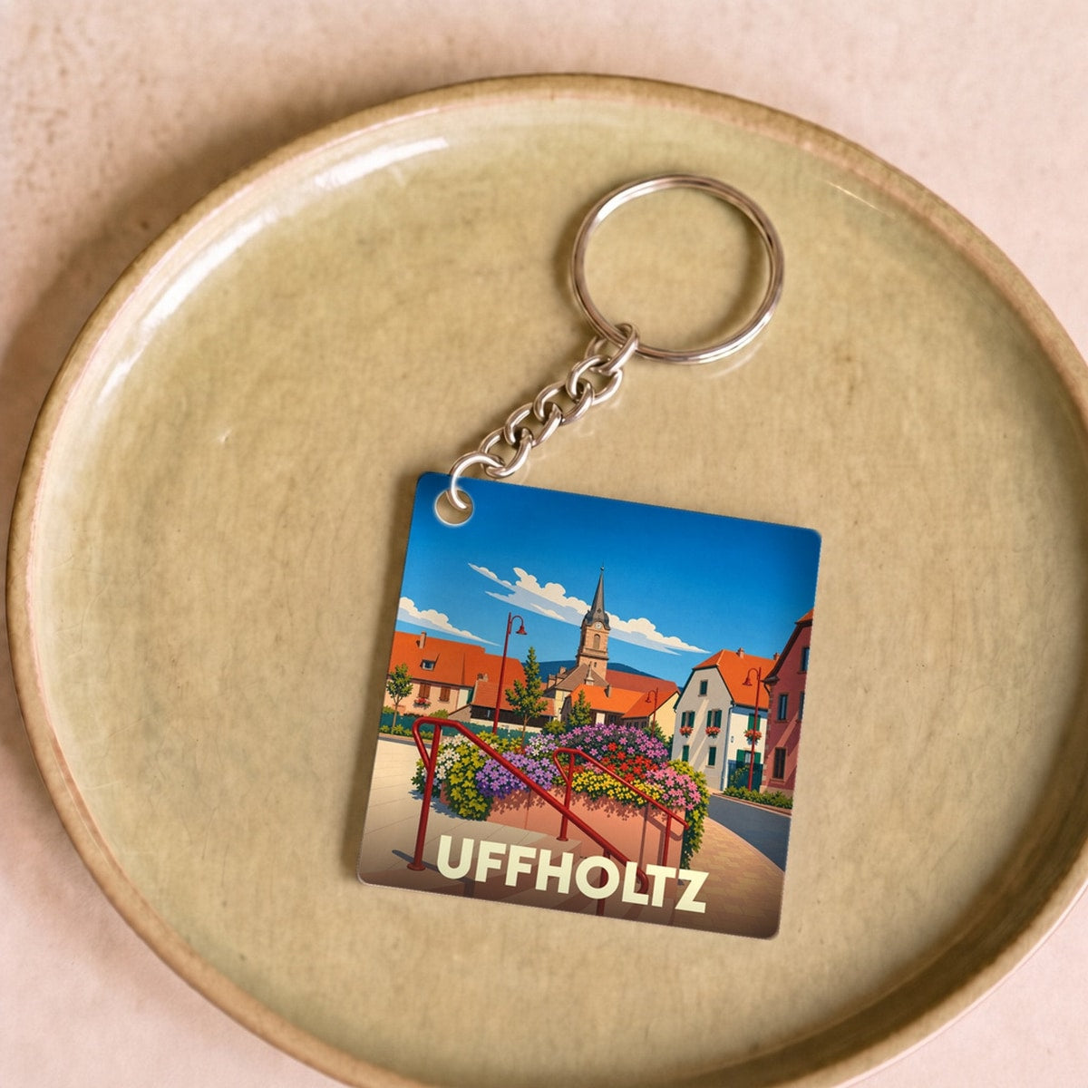 Porte-clés souvenir de la ville de Uffholtz avec une illustration colorée et stylisée.