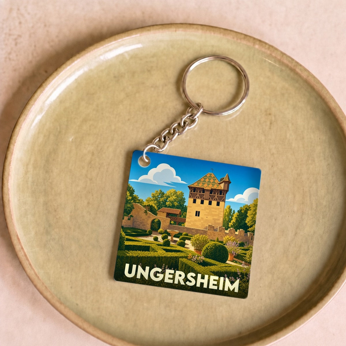 Porte-clés souvenir de la ville de Ungersheim avec une illustration stylisée de son patrimoine architectural.