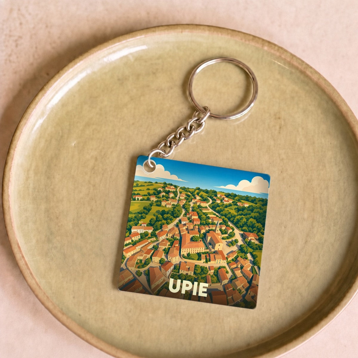 Porte-clés souvenir de la ville d'Upie avec une illustration stylisée vue du ciel.