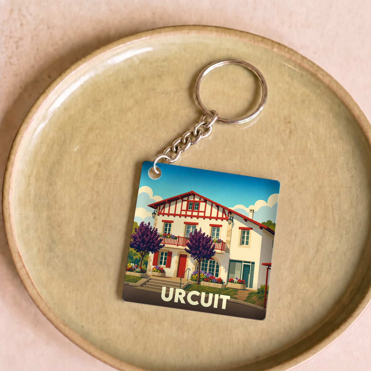 Porte-clés souvenir de la ville de Urcuit avec une illustration stylisée.