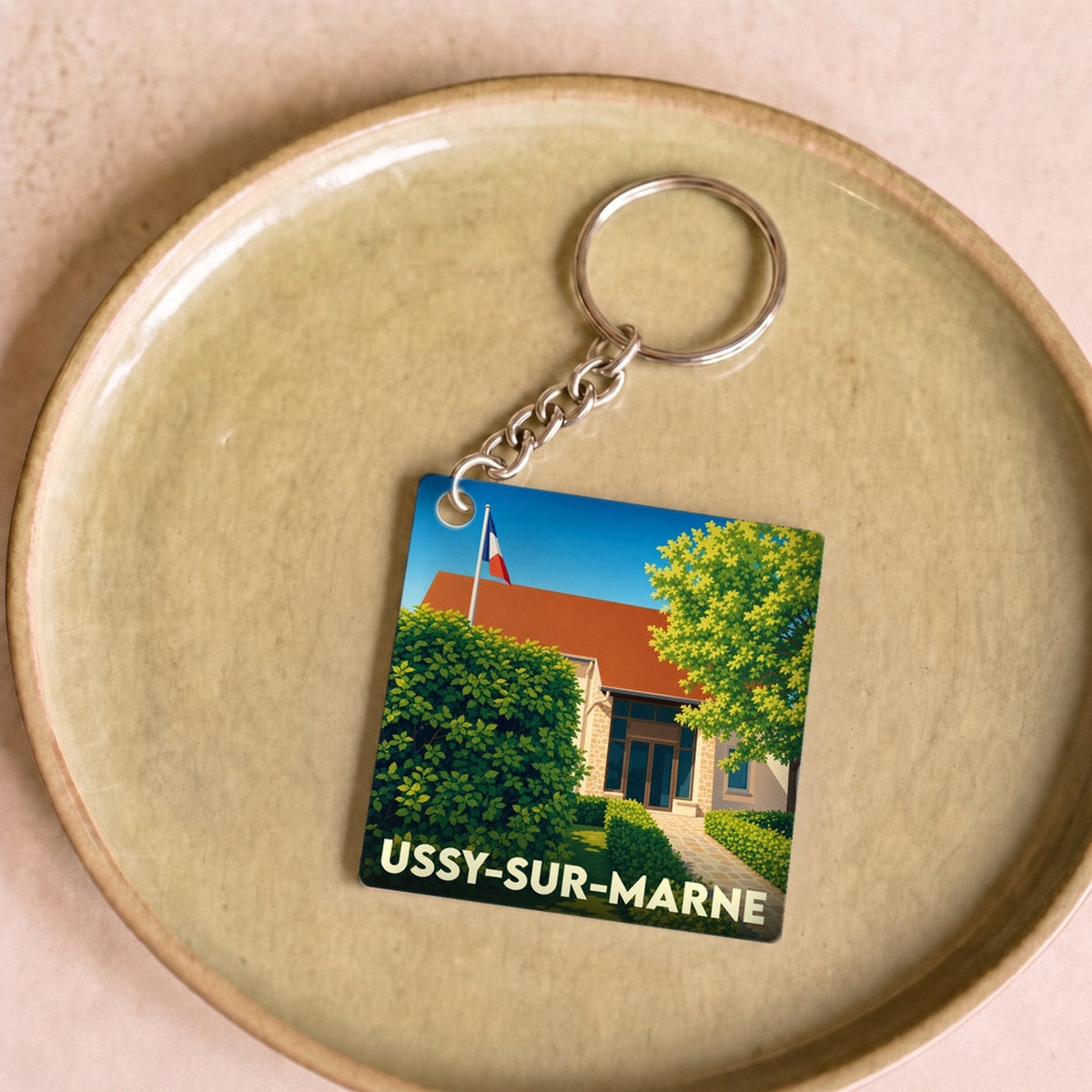 Porte-clés souvenir de la ville de Ussy-sur-Marne avec une illustration stylisée.