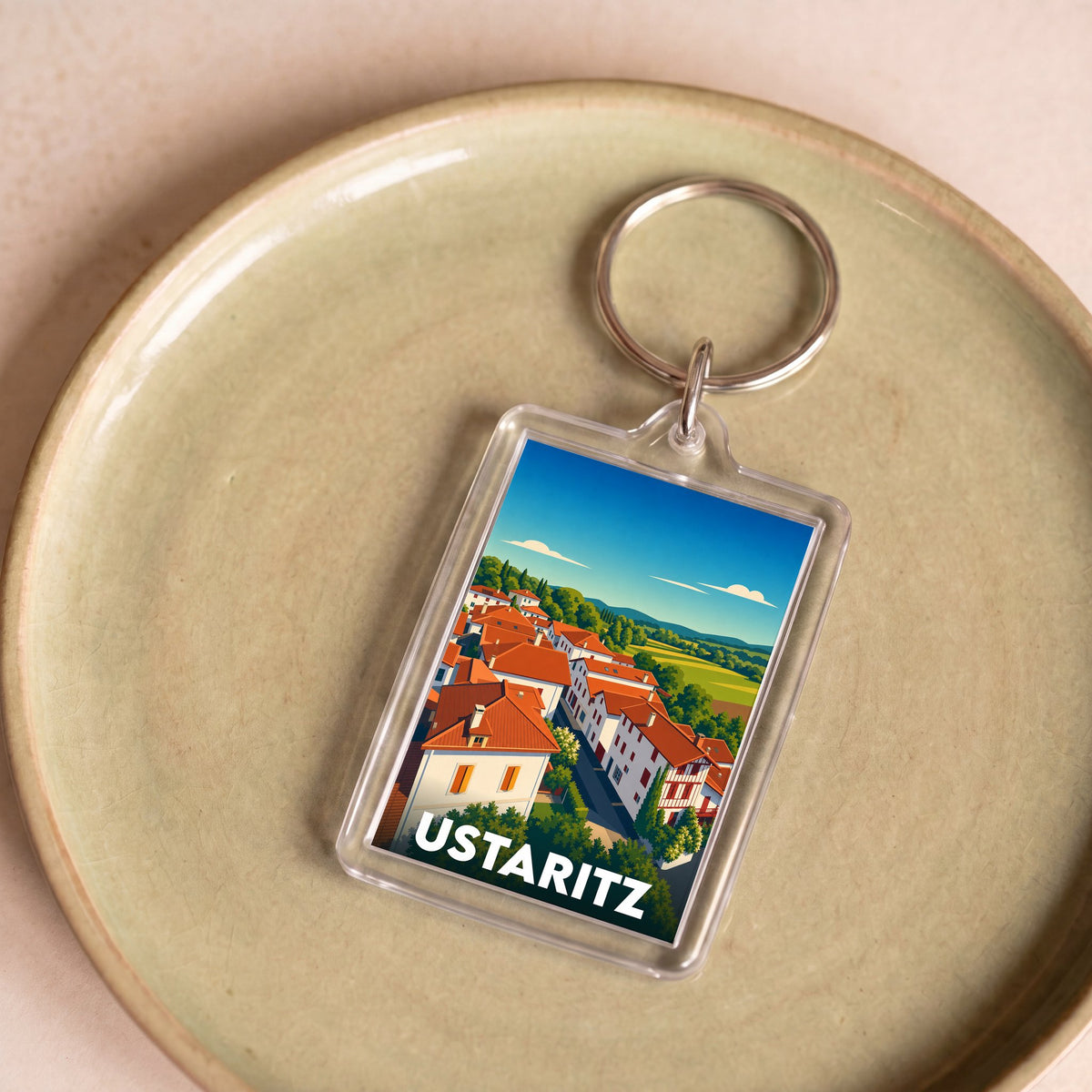 Porte-clés souvenir de la ville d'Ustaritz avec une illustration stylisée de ses maisons basques.