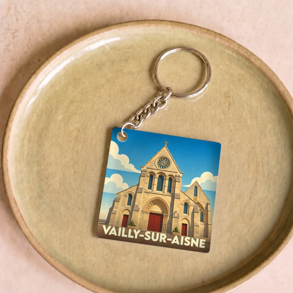 Porte-clés souvenir de la ville de Vailly-sur-Aisne avec une illustration stylisée de son église.