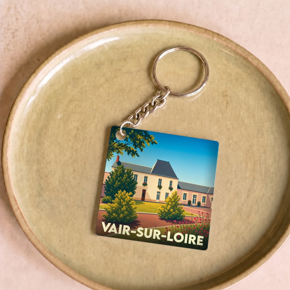 Porte-clés souvenir de la ville de Vair-sur-Loire avec une illustration stylisée d'un manoir.