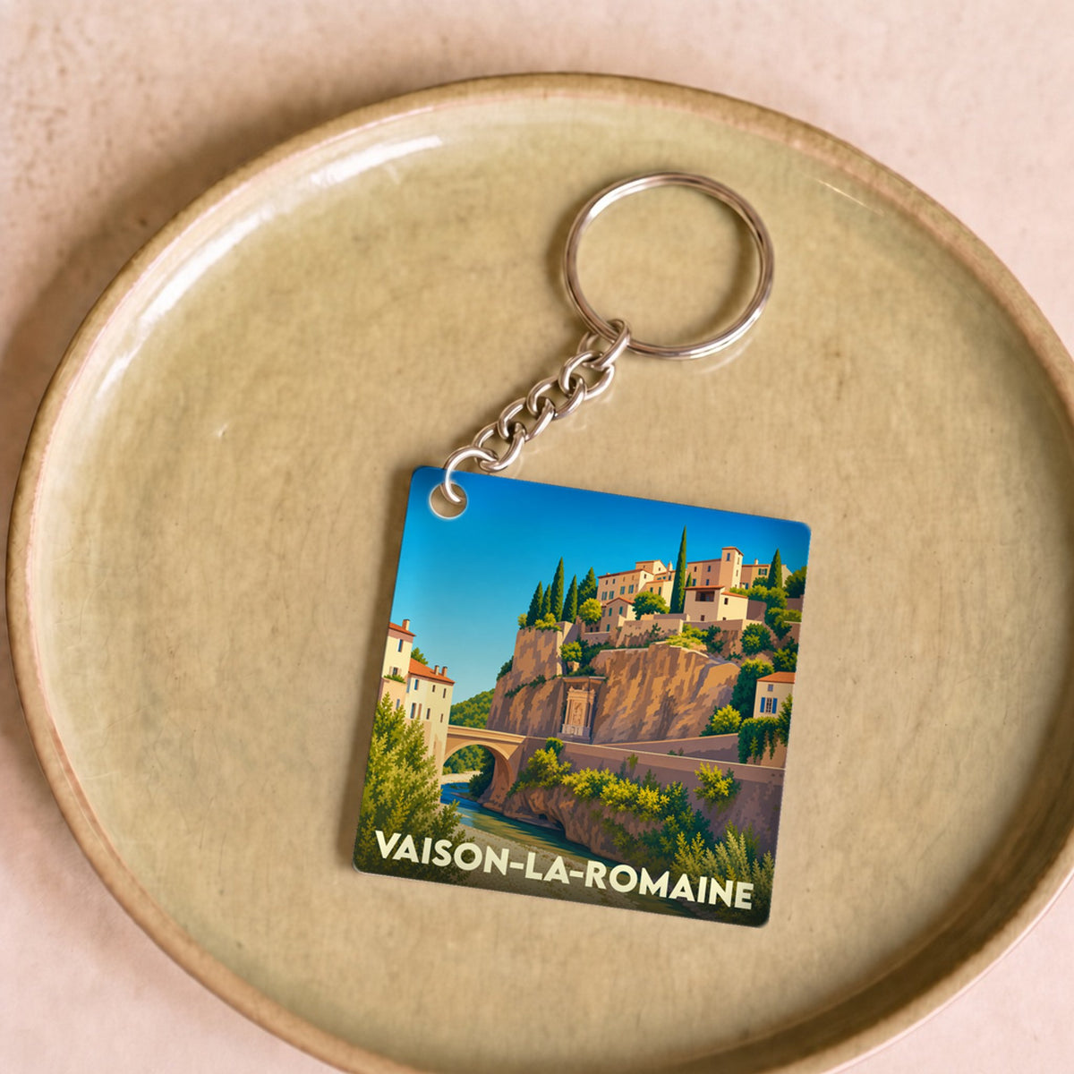 Porte-clés souvenir de la ville de Vaison-la-Romaine avec une illustration stylisée.