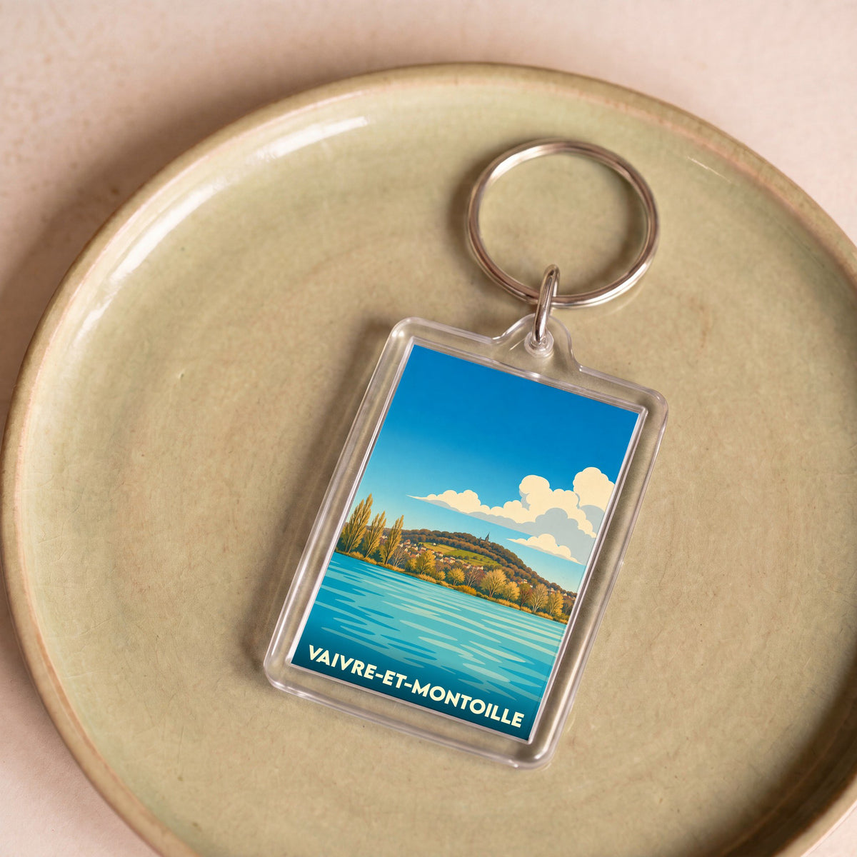Porte-clés souvenir de la ville de Vaivre-et-Montoille avec une illustration stylisée d'un lac et d'une colline.