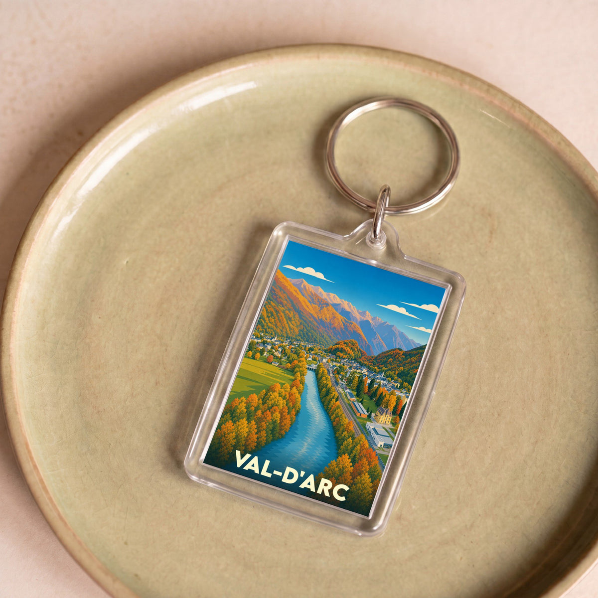 Porte-clés souvenir de la ville de Val-d'Arc avec une illustration stylisée d'un paysage montagneux.