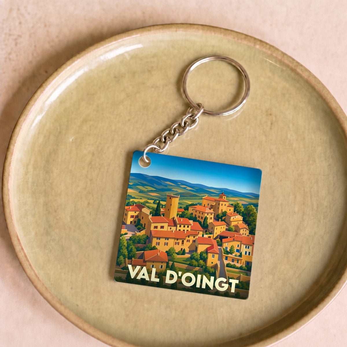 Porte-clés souvenir de la ville de Val d'Oingt avec une illustration stylisée.